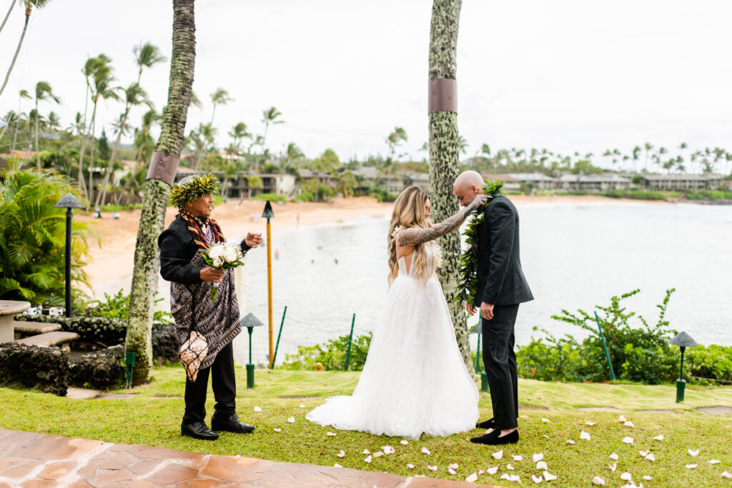 Bride placing a lei on her groom during their Maui wedding
