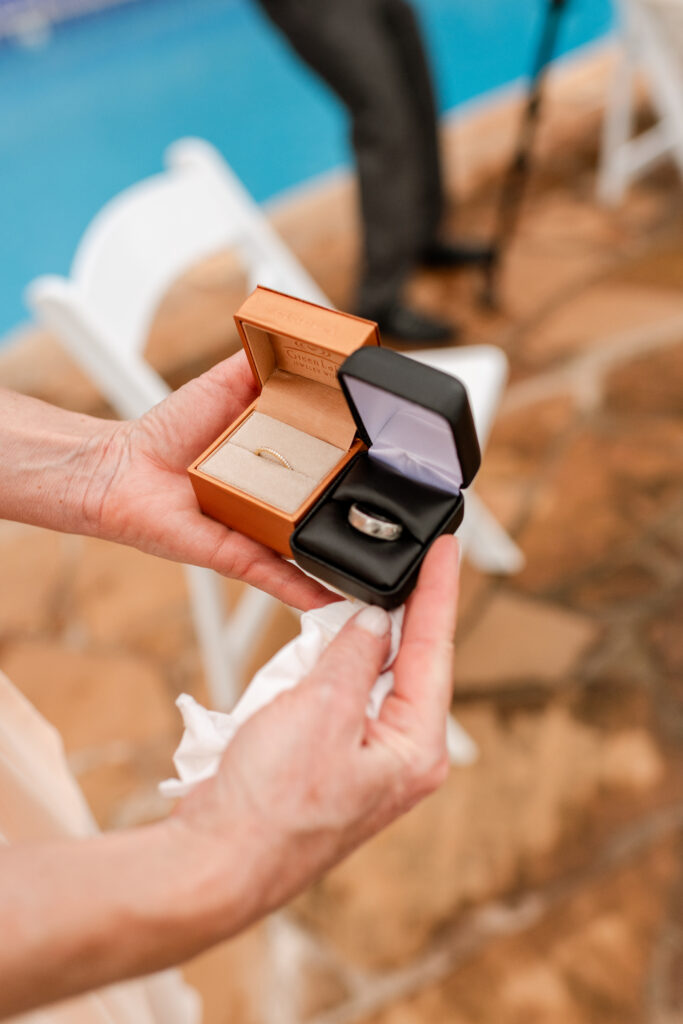 Close-up of engagement ring box held by hands at romantic Maui elopement.