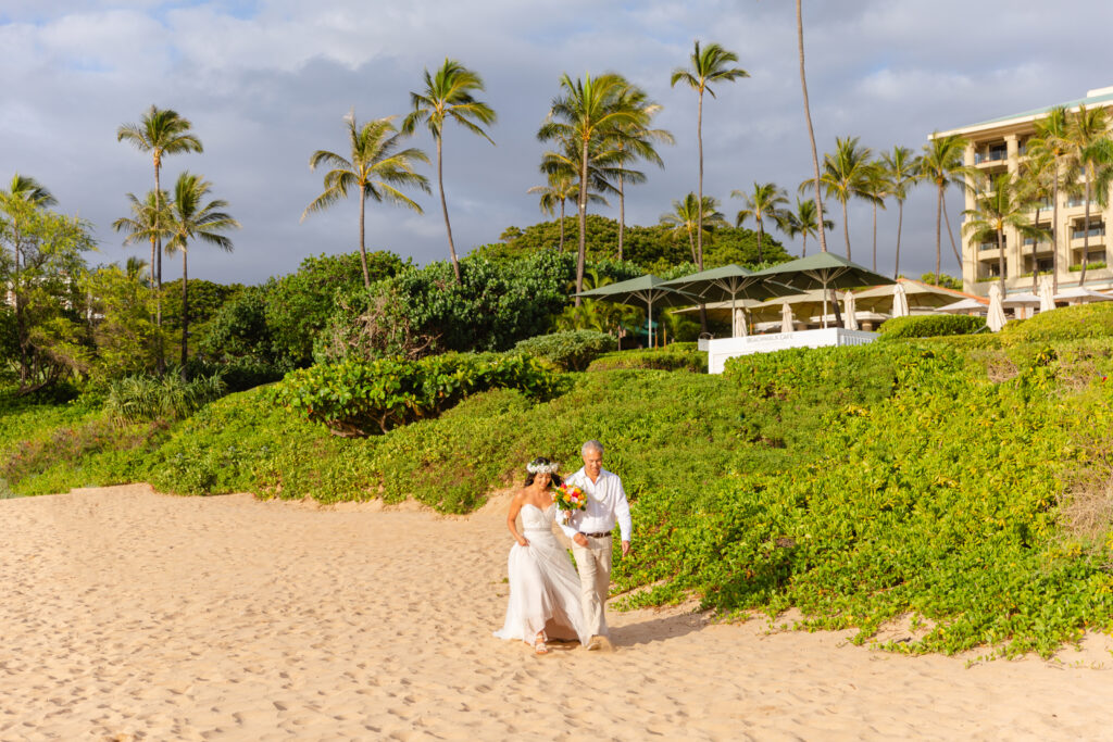 Emotional moment as the bride is walked down the beach by her father at a Maui elopement