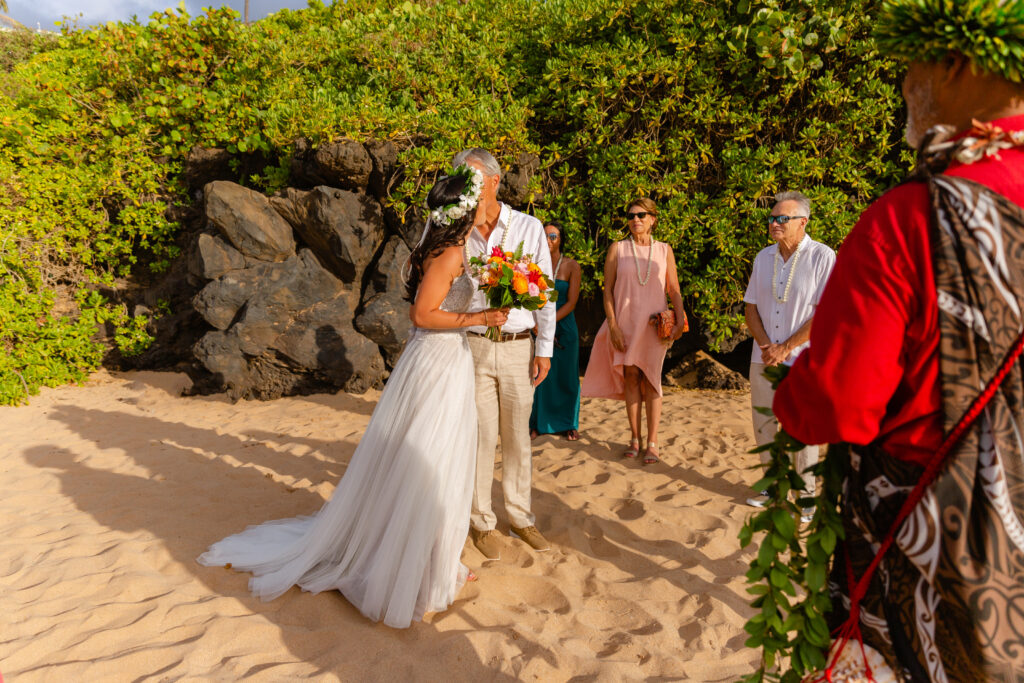 Meaningful family moment during a Maui elopement as the father walks the bride to the groom