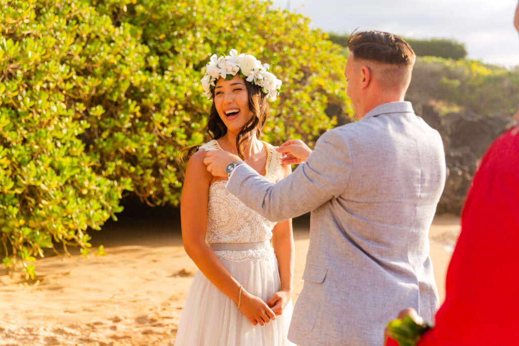 Candid moment of the groom placing a lei on the bride during an intimate Maui elopement