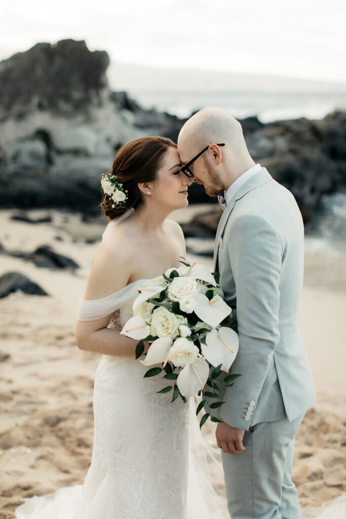 Intimate moment of a couple leaning their heads together on a Maui beach