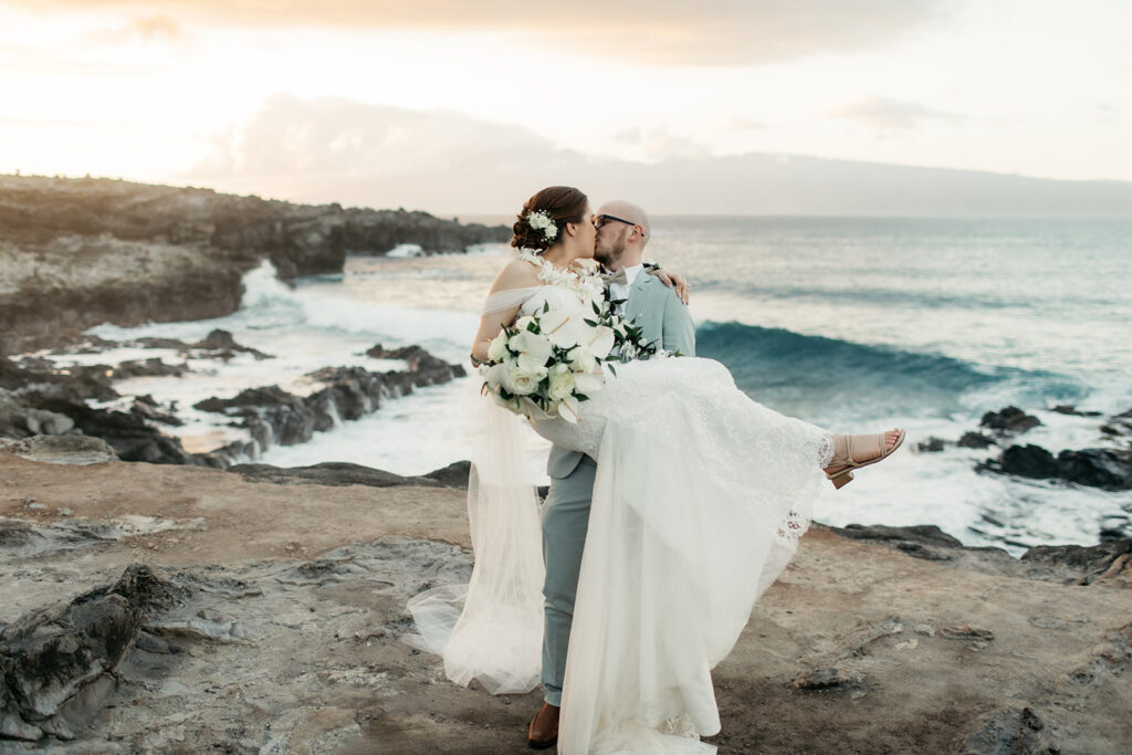 Bride and groom portrait on a Maui beach with waves crashing behind them