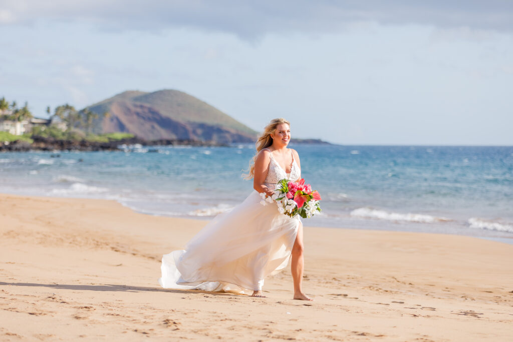 Bride wearing a classic A line wedding gown, veil flowing in the wind at a Maui beachfront venue.

