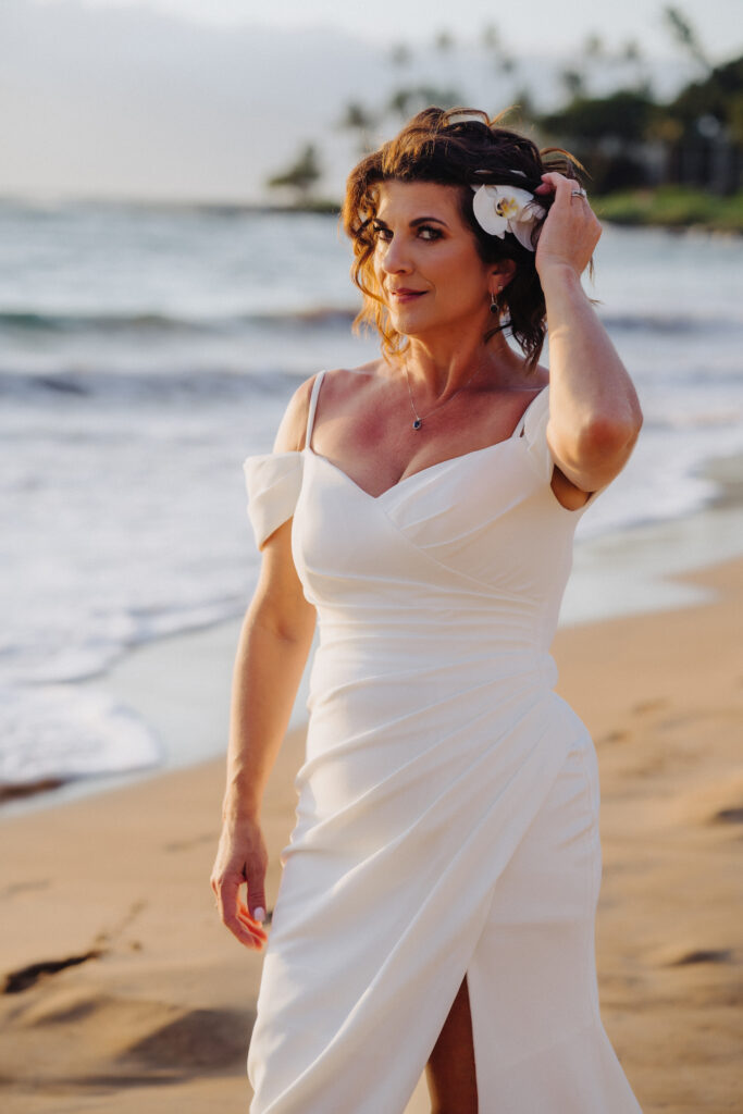 Bride in a relaxed A line gown walking barefoot along the shoreline at a Maui wedding.