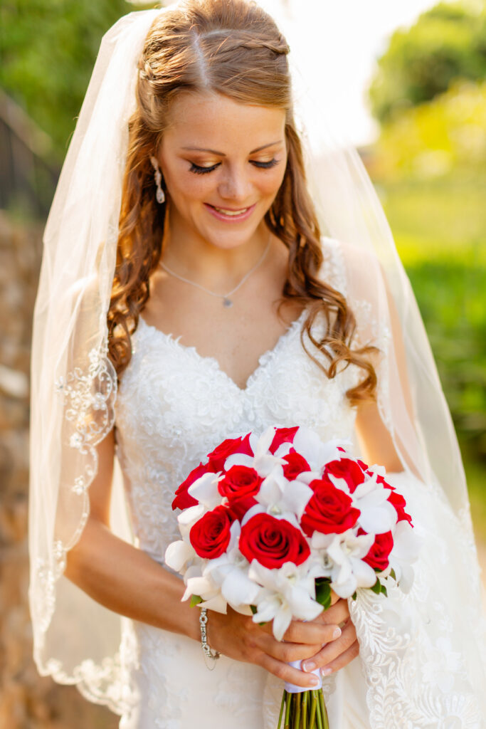 Ironwood Beach Maui bride holding red and white bouquet at sunrise

