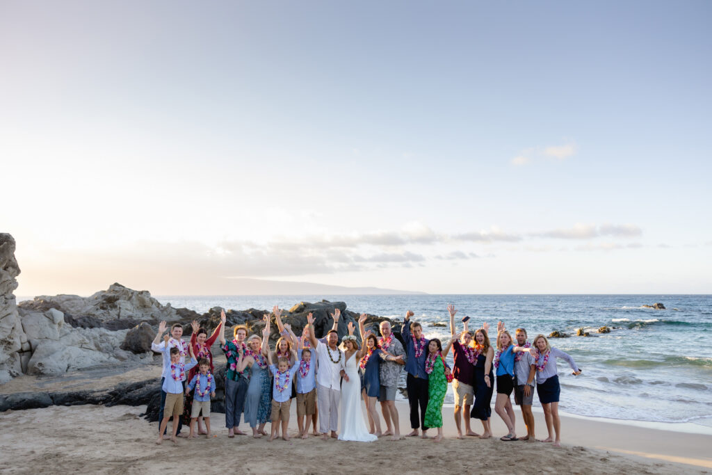 Joyful group photo on Ironwoods Beach Maui after wedding ceremony