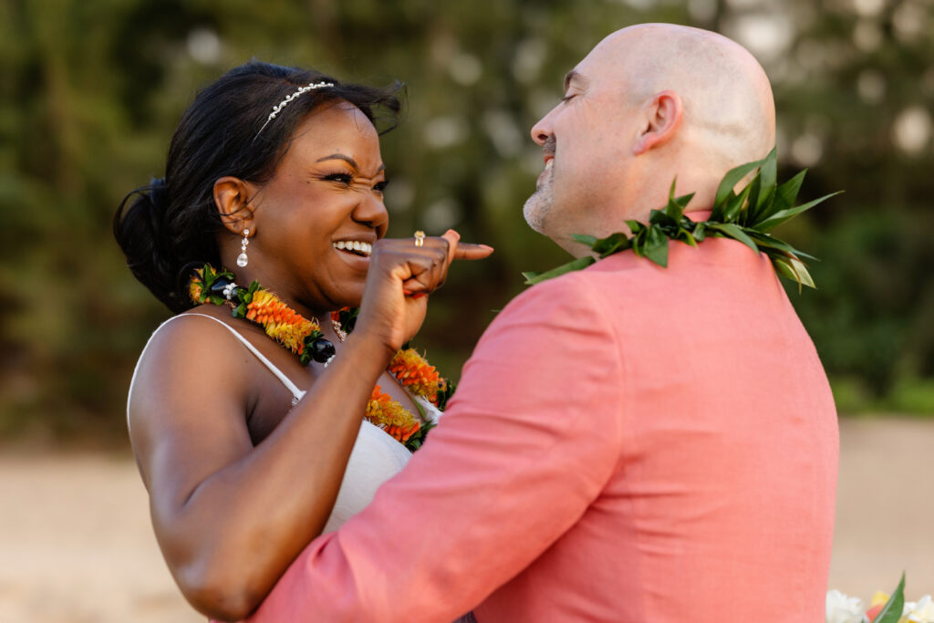 Bride laughing and holding groom close during their Maui beach elopement