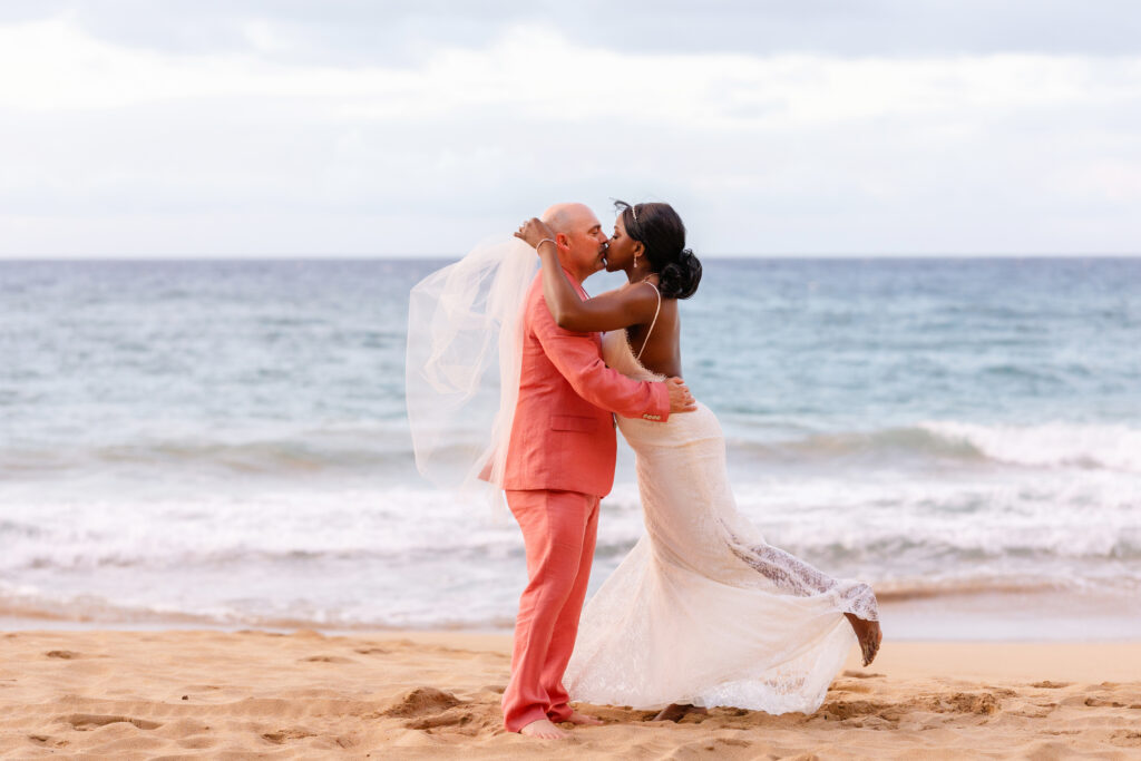 Bride and groom sharing a kiss by the ocean during their Maui beach elopement