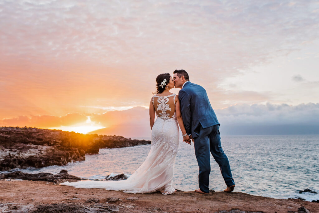 bride and groom kiss at sunset at Ironwood Beach, Maui where they just got married 