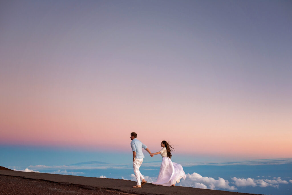 Couple walking together at Haleakalā during sunset on their Maui honeymoon