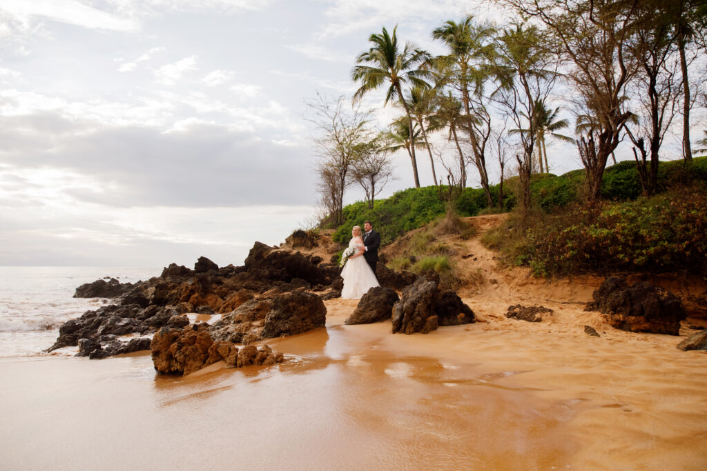 Couple standing on scenic Maui beach during destination wedding