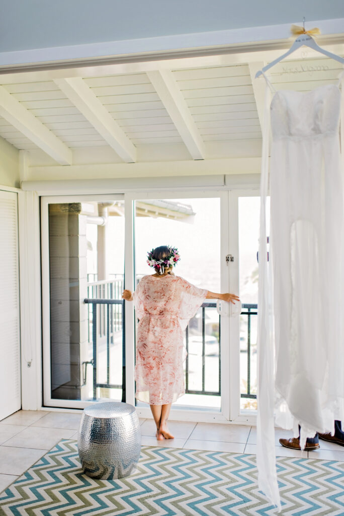 Bride looking out toward the ocean from her bridal suite before a Maui elopement ceremony.