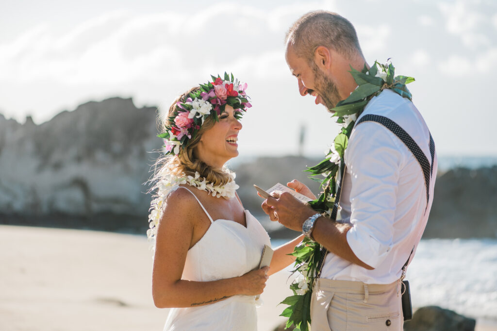 Couple reading personal vows during an intimate Maui beach wedding ceremony.