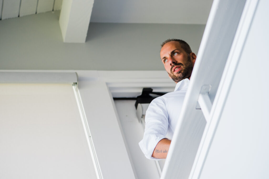 Groom getting ready before a Maui elopement in a bright oceanfront vacation rental.