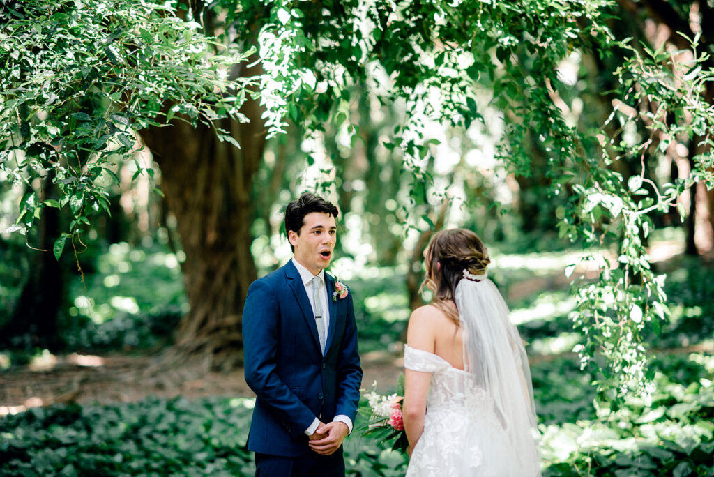 Groom reacting during a first look before a Maui wedding surrounded by tropical greenery.